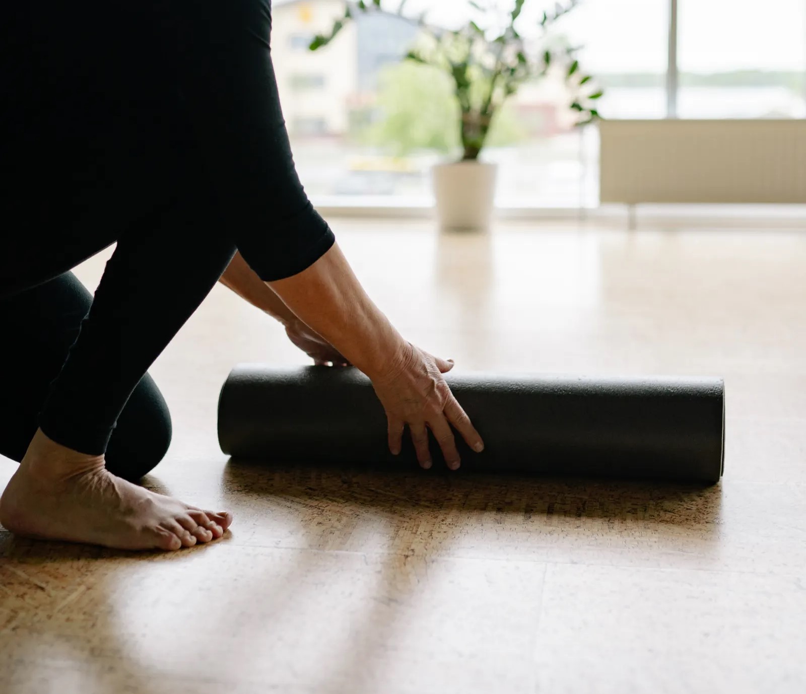 Older woman preparing a yoga mat for a gentle yoga session
